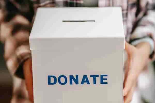 crop anonymous person showing donation box
